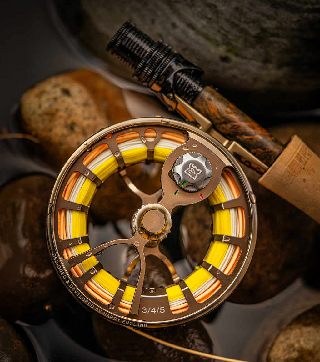 Image of Hardy resonate reel on Hardy fly rod on top of water and rocks